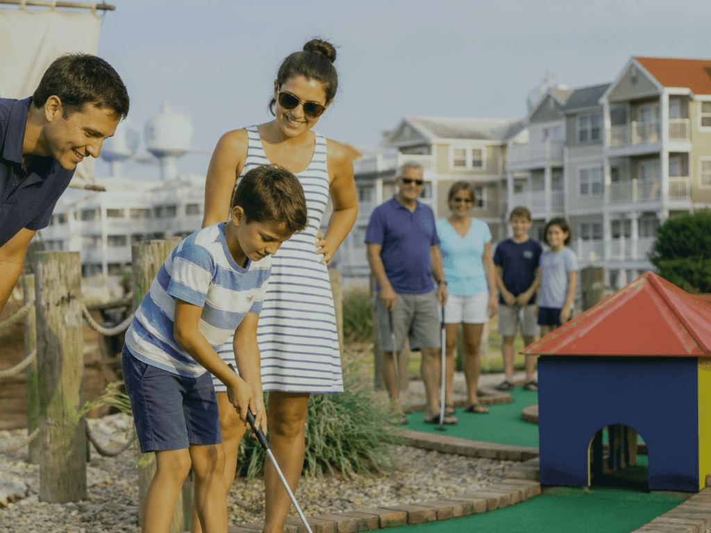 Kids lining up a putt at an Ocean City mini golf course before the afternoon crowds arrive