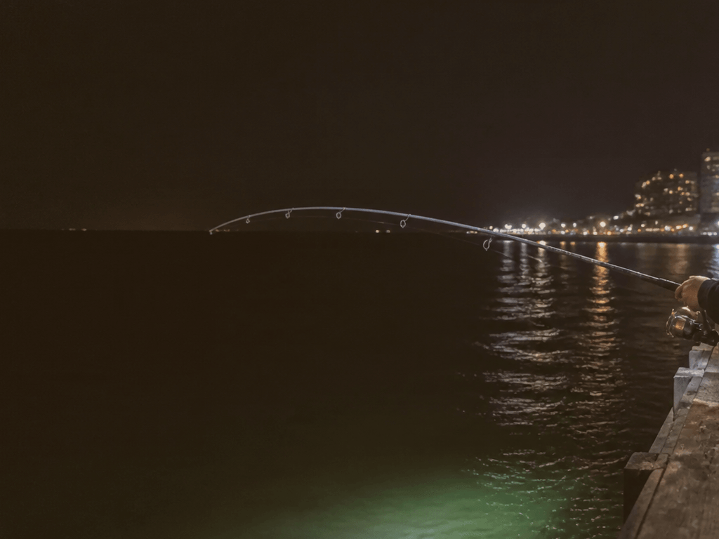 Headlamp and tackle box on pier rail during night fishing in Ocean City Maryland