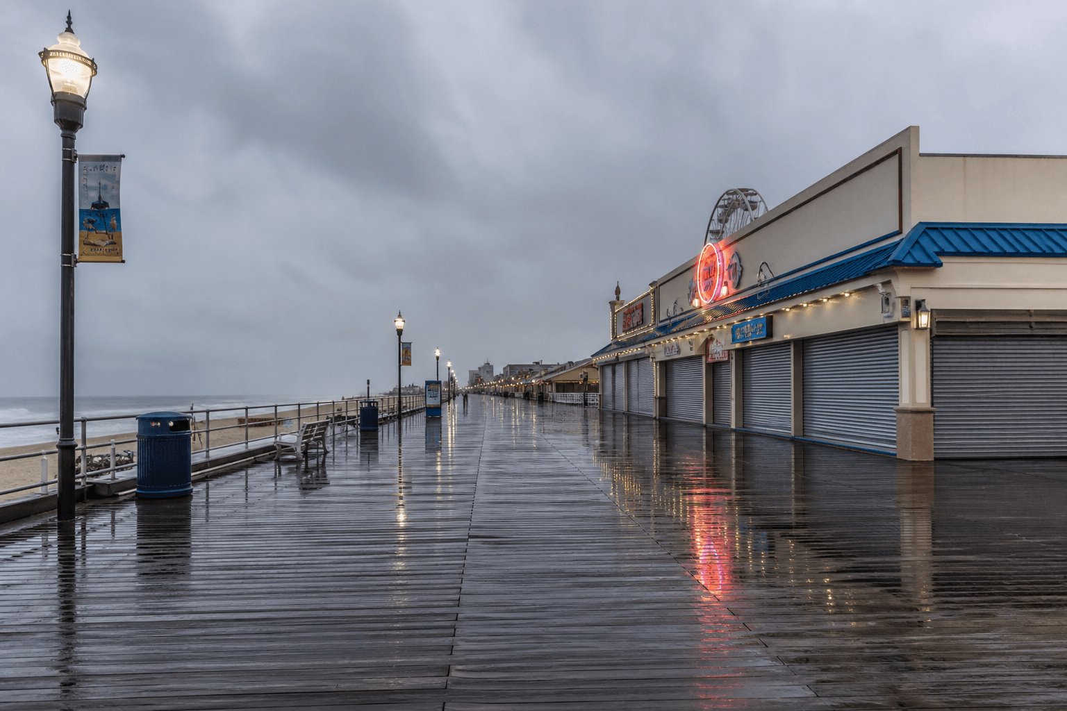 Soft rainy April light on a quiet Ocean City Boardwalk with wet planks and coastal atmosphere — Beach Blog photo, Ocean City, Maryland